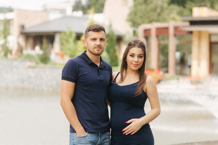 Pregnant woman and her husbant hug each other and smileの写真素材