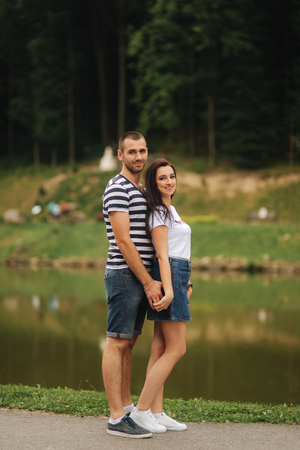 Beautiful couple walking in the park near the lakeの写真素材