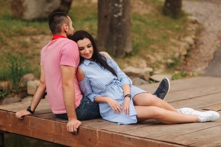 A guy and a girl enjoy each other in a romantic atmosphere, sits on the pierの写真素材