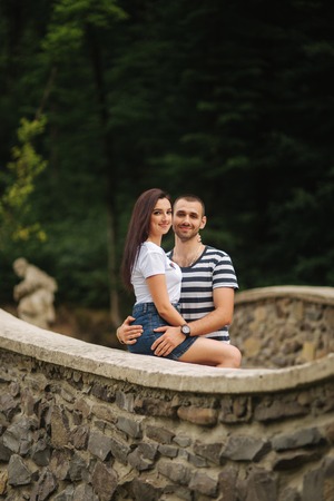 Young couple in love spending time together near the big old bridge.の写真素材