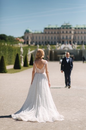 Beautiful young bride with her handsome groom walking in palace Belvedereの写真素材