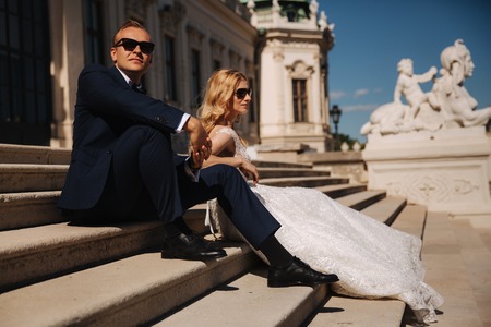 Fashion photo of wedding couple. Groom wears blue suit and tie bow. Bride wears white wedding dressの写真素材