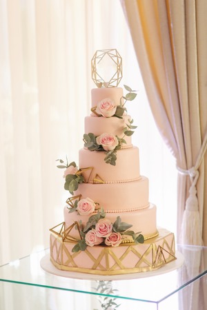 Beautiful wedding cake decorated with flowers. Pink color of cake. Powder roseの写真素材