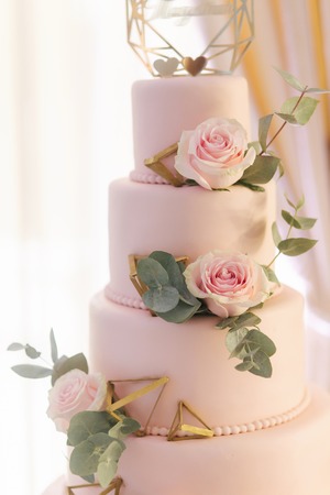 Beautiful wedding cake decorated with flowers. Pink color of cake. Powder roseの写真素材