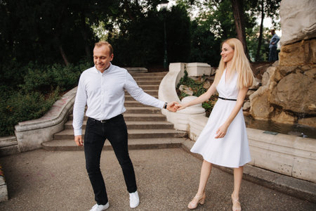 Young couple walking in the park. The have fun and rejoice. Black and white clothes