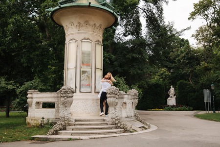 Beautiful cuple stand on the stairs and hug each other. Man and woman walking in the park. LoveStoryの写真素材