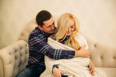 Happy couple in holiday spirit showing affection for one another. Dressed in plaid clothes. Gentle...