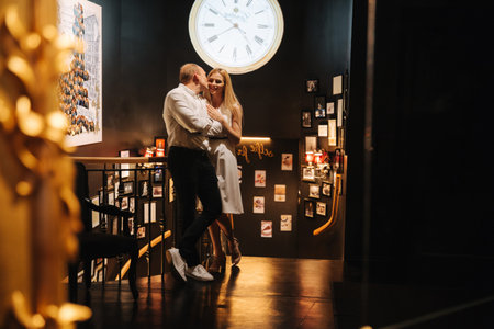 Attractive couple spend time in cafe. Man and woman look to each other and smile. Love story