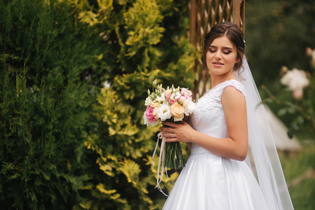 Bride in park with bouquet. Spring. sunny weather.の写真素材