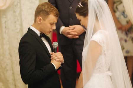 Groom and bride at the wedding ceremony in the churchの写真素材