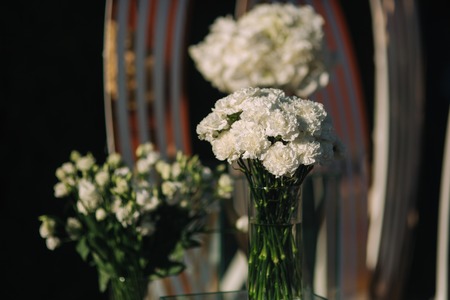 Weddind decoration on open air. Floral decor of a beautiful white arch. Beautiful beckground view of treesの写真素材
