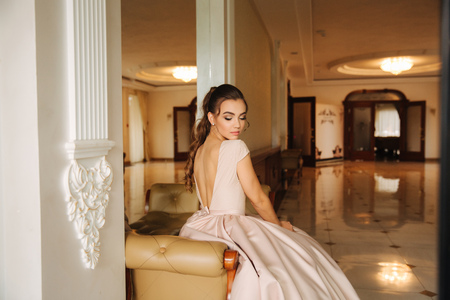 Beautiful stunning young lady in amazing dress sitting on luxury armchairの写真素材