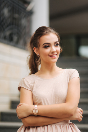 Model with brunette hair in a powder color dress and with evening makeupの写真素材