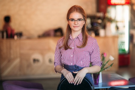 Beautiful waitress standing in cafe. waiting for customerの写真素材