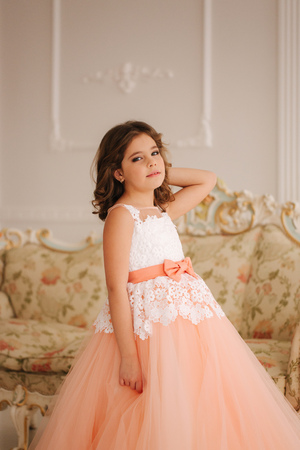 Happy little princess in beautiful dress walk though the big studioの写真素材