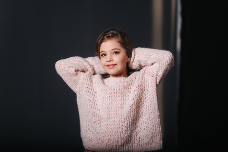 Beautiful young model in a peach color knitted sweater. Fashion makeup and hairstyleの写真素材