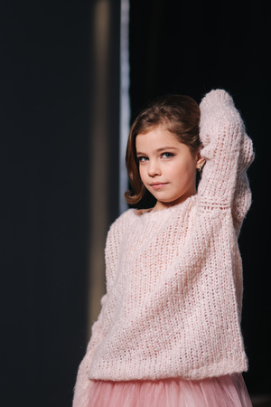 Beautiful young model in a peach color knitted sweater. Fashion makeup and hairstyleの写真素材
