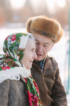 Senior people sits on the benck in the park. Happy elderly couple spend time outside in winterの写真素材