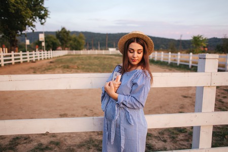 Happy pregnant woman hold a book in her hands and smile. Outsideの写真素材