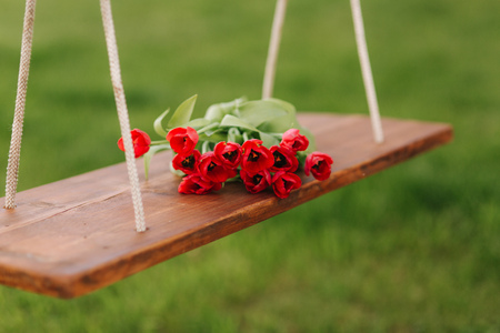 Beautiful red flowers of wooden swing outside. Springの写真素材