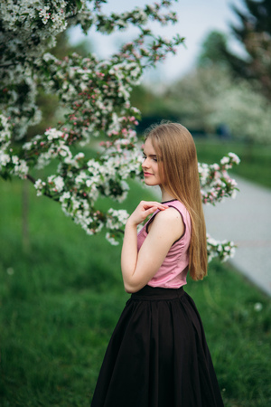 Beautiful blond hair girl standing in front of the blooming tree. beautiful springの写真素材