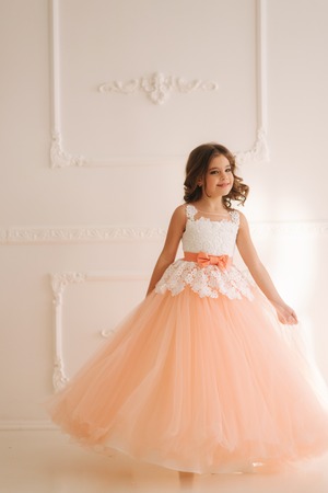 Happy little princess in beautiful dress walk though the big studio. spin aroundの写真素材