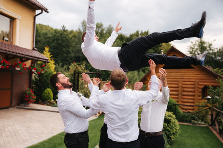 Stylish groomsman with groom standing on the backyard and prepare for the wedding ceremony. Friend spend time together outsideの写真素材