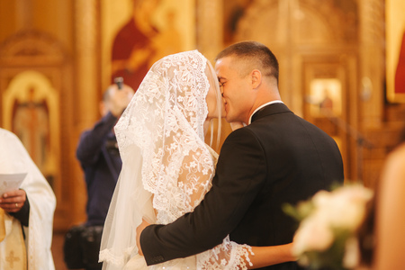 Groom and bride kiss each other in the churchの写真素材