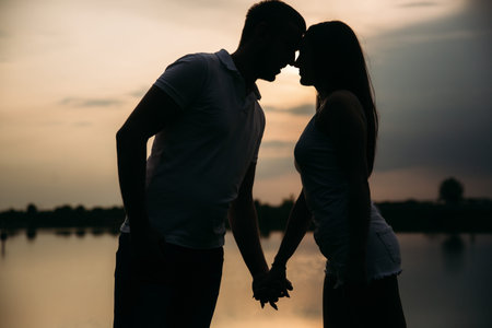 Silhouette of beautiful couple. lake in background