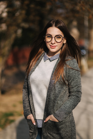 Beautiful girl in gray jacket and shirt wear fashion sunglasses. Young girl smileの写真素材