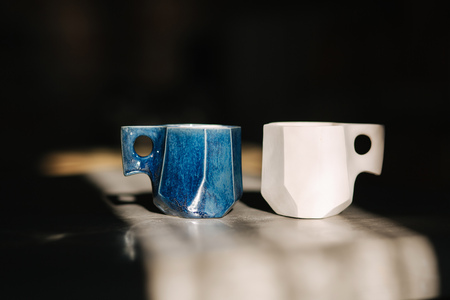 Ceramic cup for coffee on the table. Right is unfinished, left is readyの写真素材