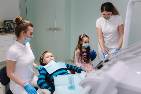 Pediatric dentist with assistant with little boy and girlの写真素材