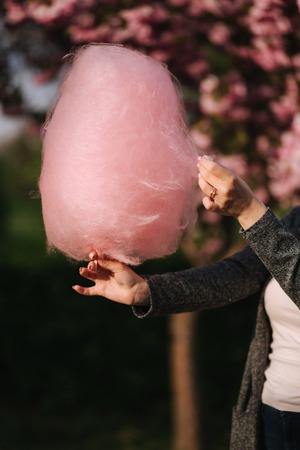 Hand of woman holding a pink cotton candyの写真素材