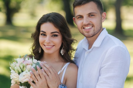 Portrait of beautiful couple in white clothes. Handsome man and elegant lady. Brilliant smileの写真素材