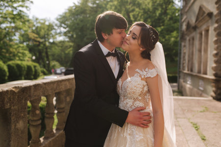 Groom kisses bride on her cheek. Beautiful coupleの写真素材