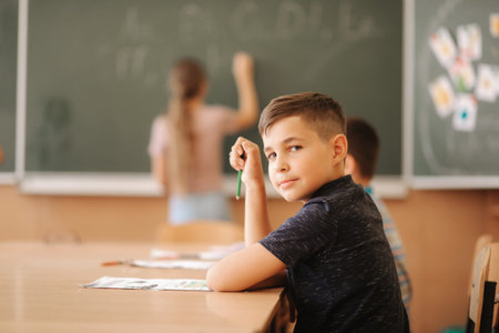 Group of school kids with pens and notebooks writing test in classroom. education, elementary...