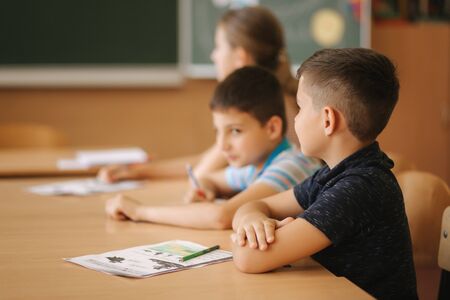 Schoolboy rise hand in classroom. Elementary school. Educationの写真素材
