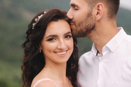 Close up portrait of beautiful couple in mountains. Happy woman with man. Elegant female with her husbandの写真素材