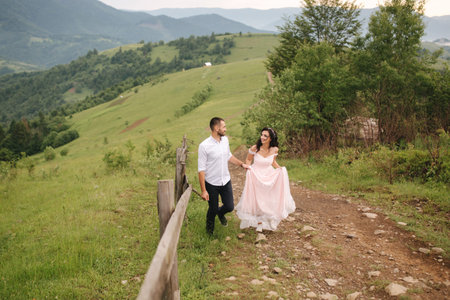 Beautiful young wedding couple standing on the green slope, hill. Groom and bride in Carpathian...