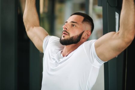A young athlete trains in the gym. Shows the muscles of the back and chestの写真素材