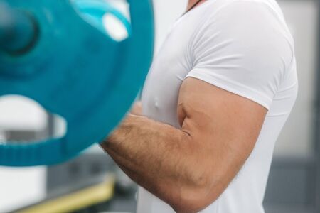 A young athlete trains in the gym. Trians biceps musculesの写真素材