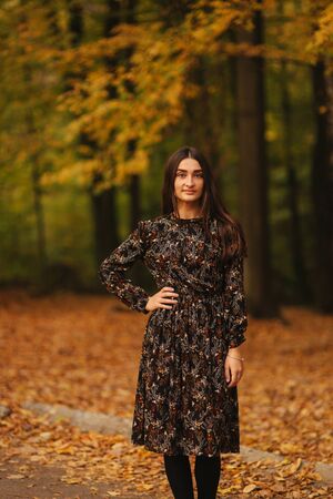 Beautiful female model walking in the forest in autumn weatherの写真素材