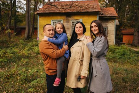 Family portrait in the forest backgroung of old house. Mother father and two daughter. Happy familyの写真素材