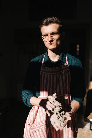 Male potter works with clay. Hands of man creating ceramic productの写真素材