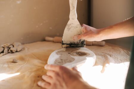 Hands of potter fill the form with a ceramic in the shape of a butterfly. Close up of handsの写真素材
