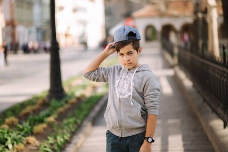 Portrait of little boy in cap. Stylish boy walking in the cityの写真素材