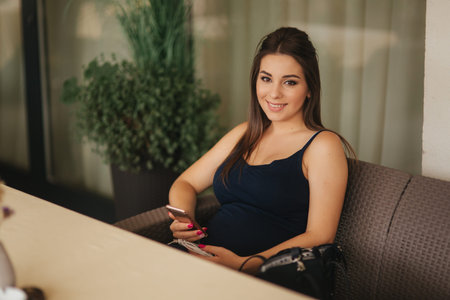 Beautiful pregnant lady in blue dress smile. Tenderness woman walk outside. Six months of pregnancy