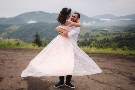 Beautiful wedding couple in Carpathian mountains. Handsome man with attractive woman. Bride spin aroundの写真素材