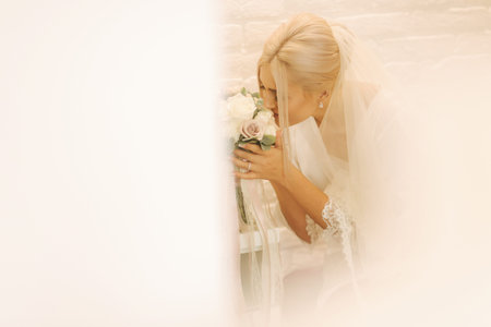 Morning of beautiful blond hair bride near the wedding dress into an exiting white negligeeの写真素材