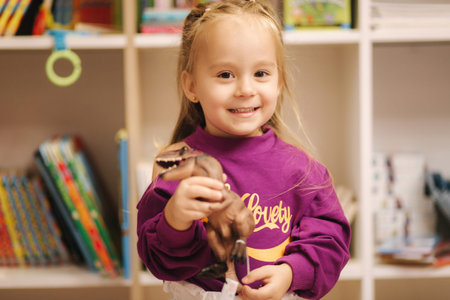 Adorable little girl shopping for toys. Cute female in toy store. Happy young girl selecting toy